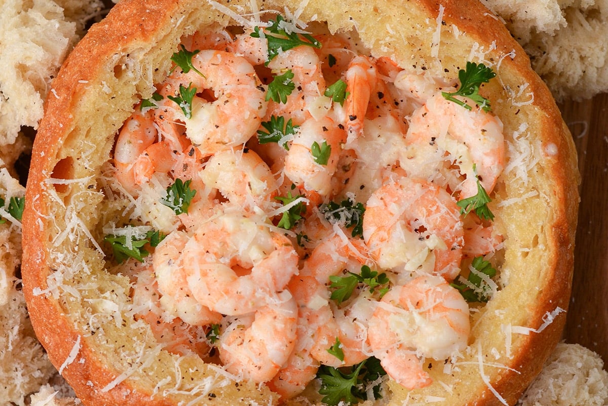 close up of shrimp in a scampi bowl with cheese and parsley