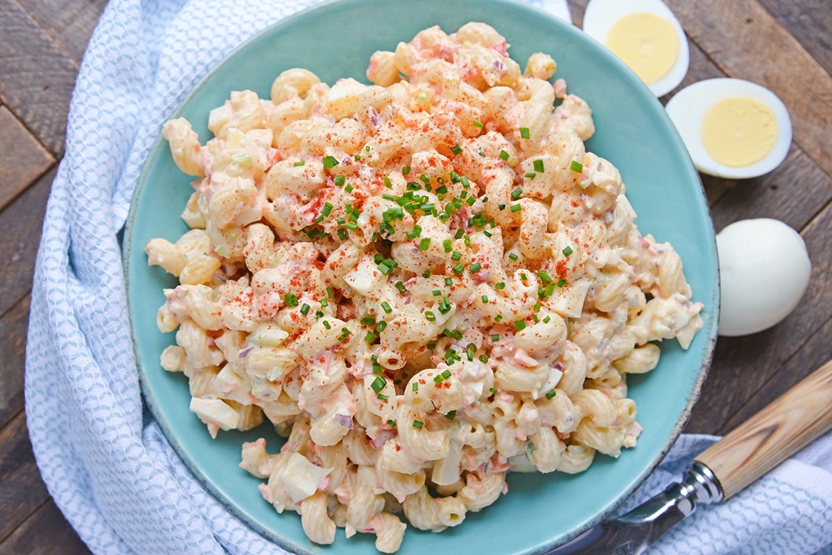 overhead of deviled egg pasta salad with chives and paprika