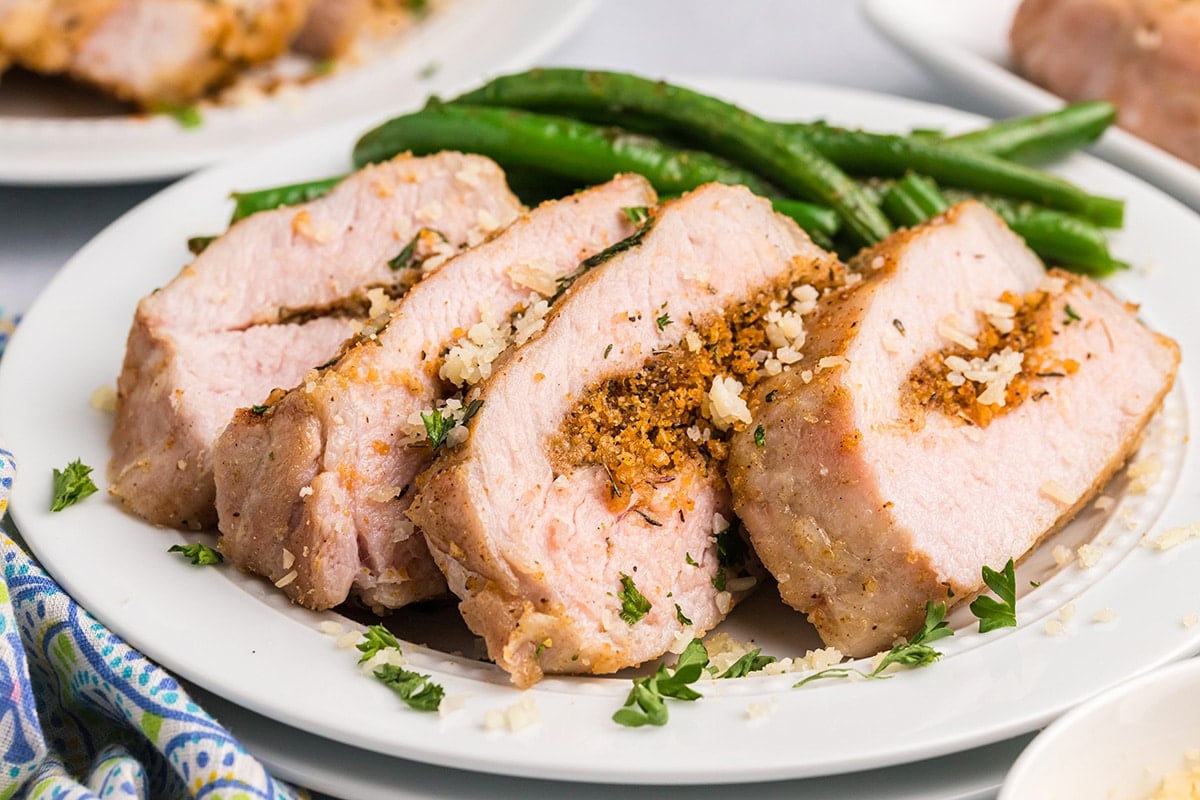 sliced pork chop on plate with green beans