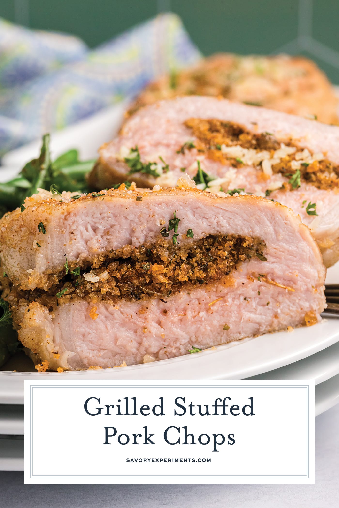 close up of grilled stuffed pork chop cut in half with text overlay for pinterest