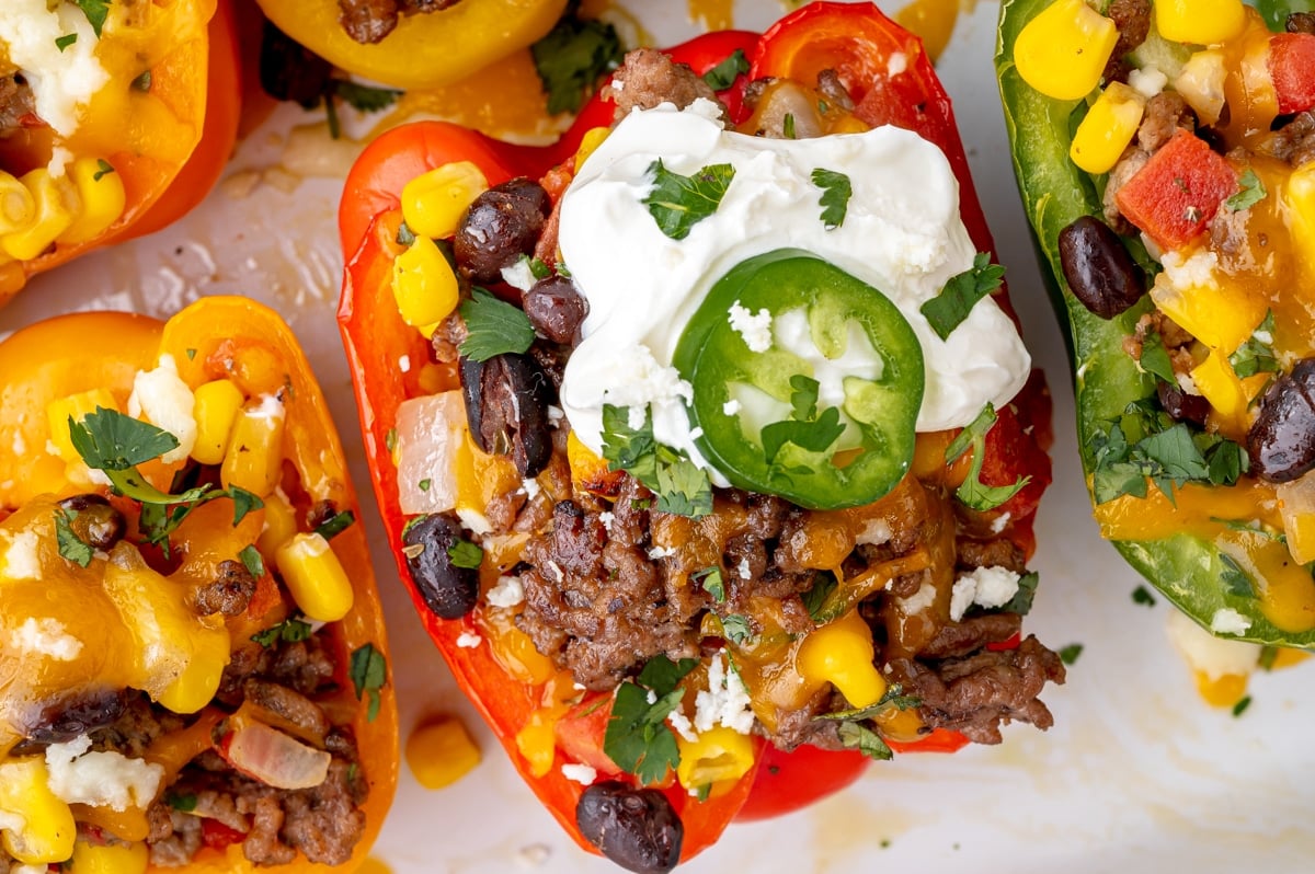 mexican stuffed pepper topped with sour cream and jalapeno
