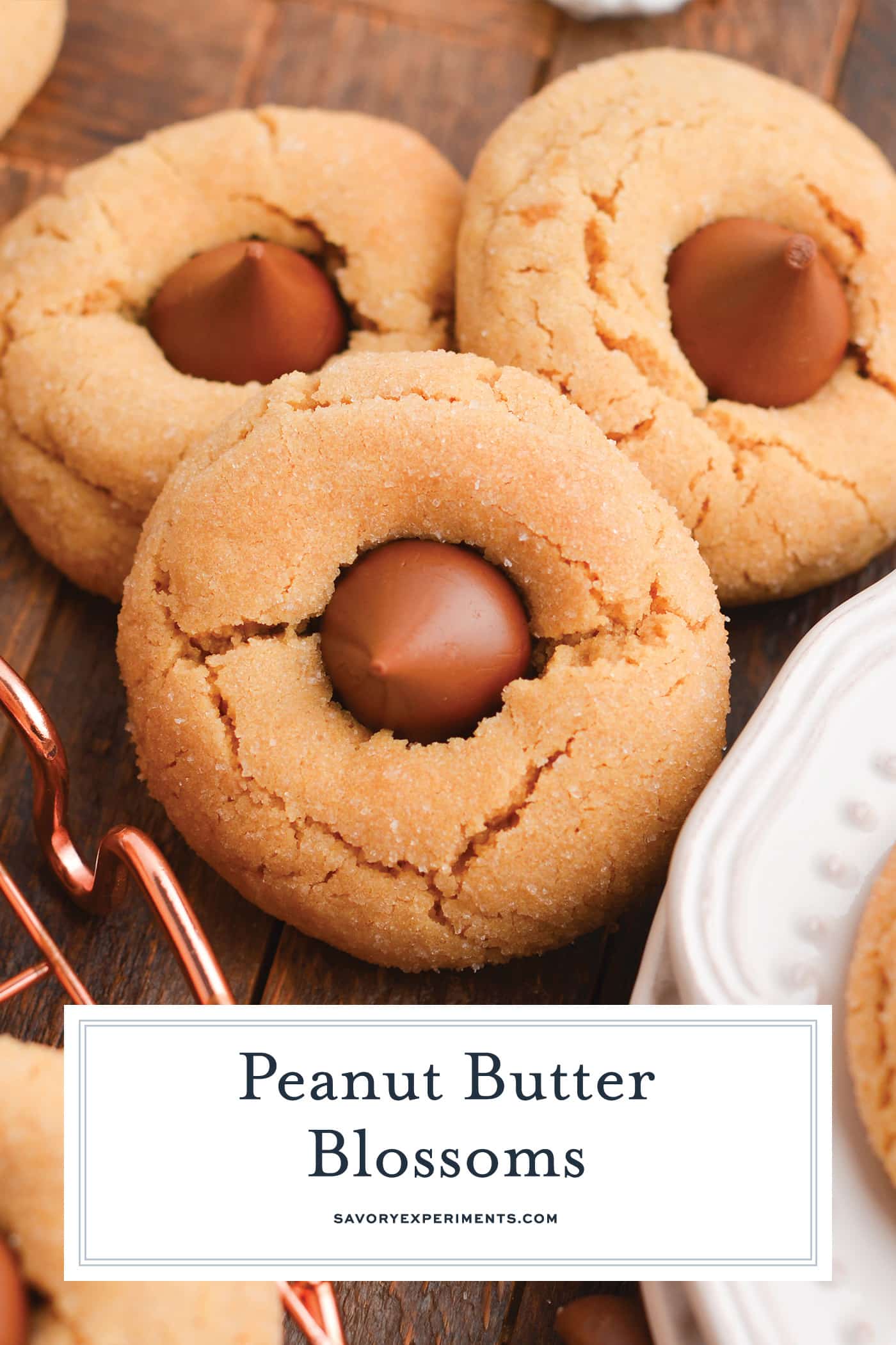 angled shot of three peanut butter blossoms with text overlay for pinterest