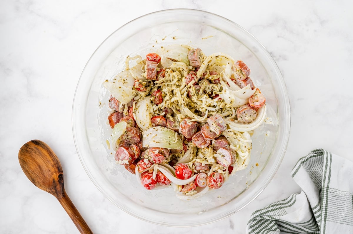 pesto pasta ingredients mixed in bowl