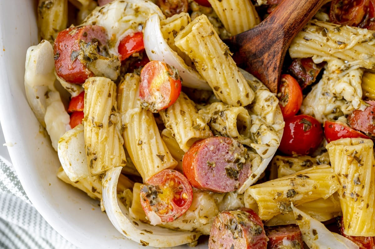 serving spoon in dish if pesto sausage pasta bake