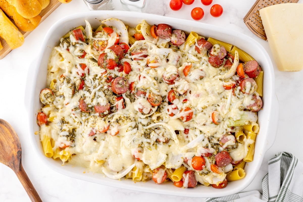 melted cheese over pesto sausage pasta bake