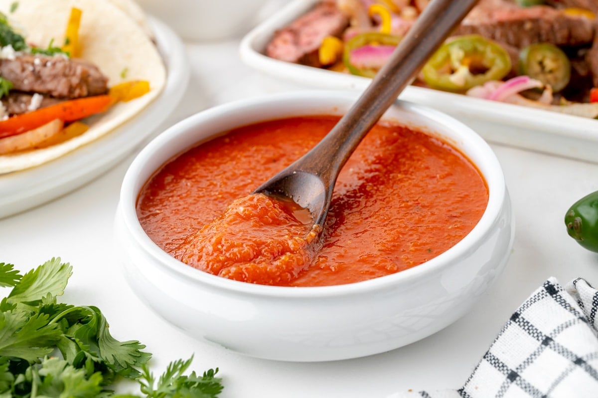 angled shot of spoon in bowl of ranchero sauce