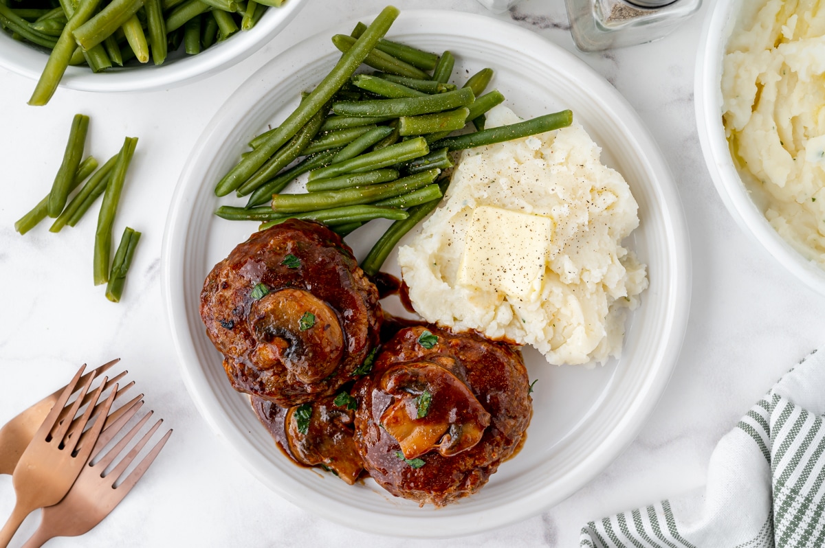 overhead shot of plate of salisbury steak, potatoes and green beans