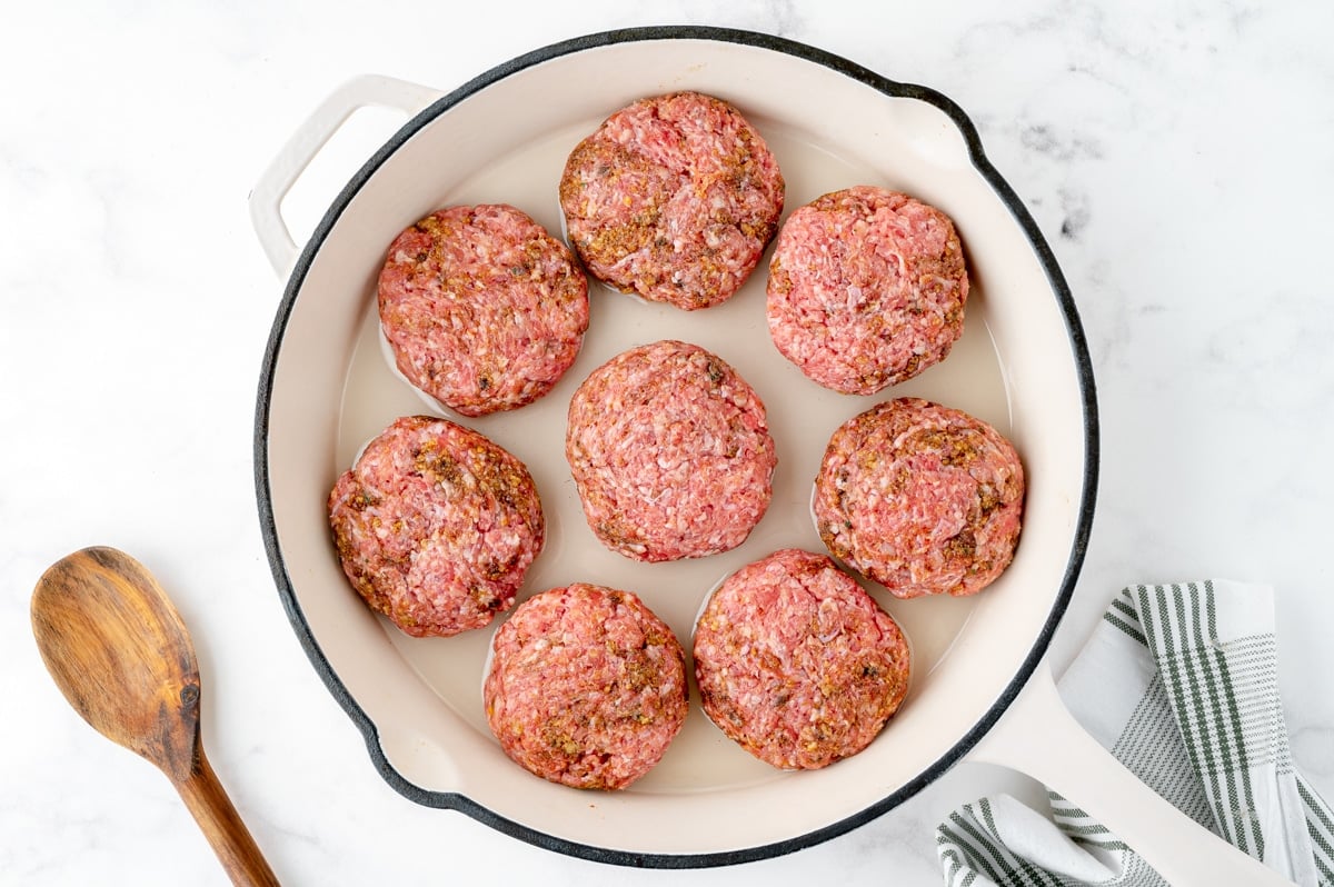 raw salisbury steak patties in a skillet