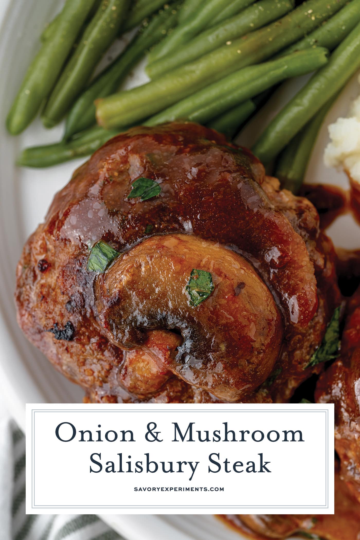 salisbury steak on a plate with beans with text overlay for pinterest