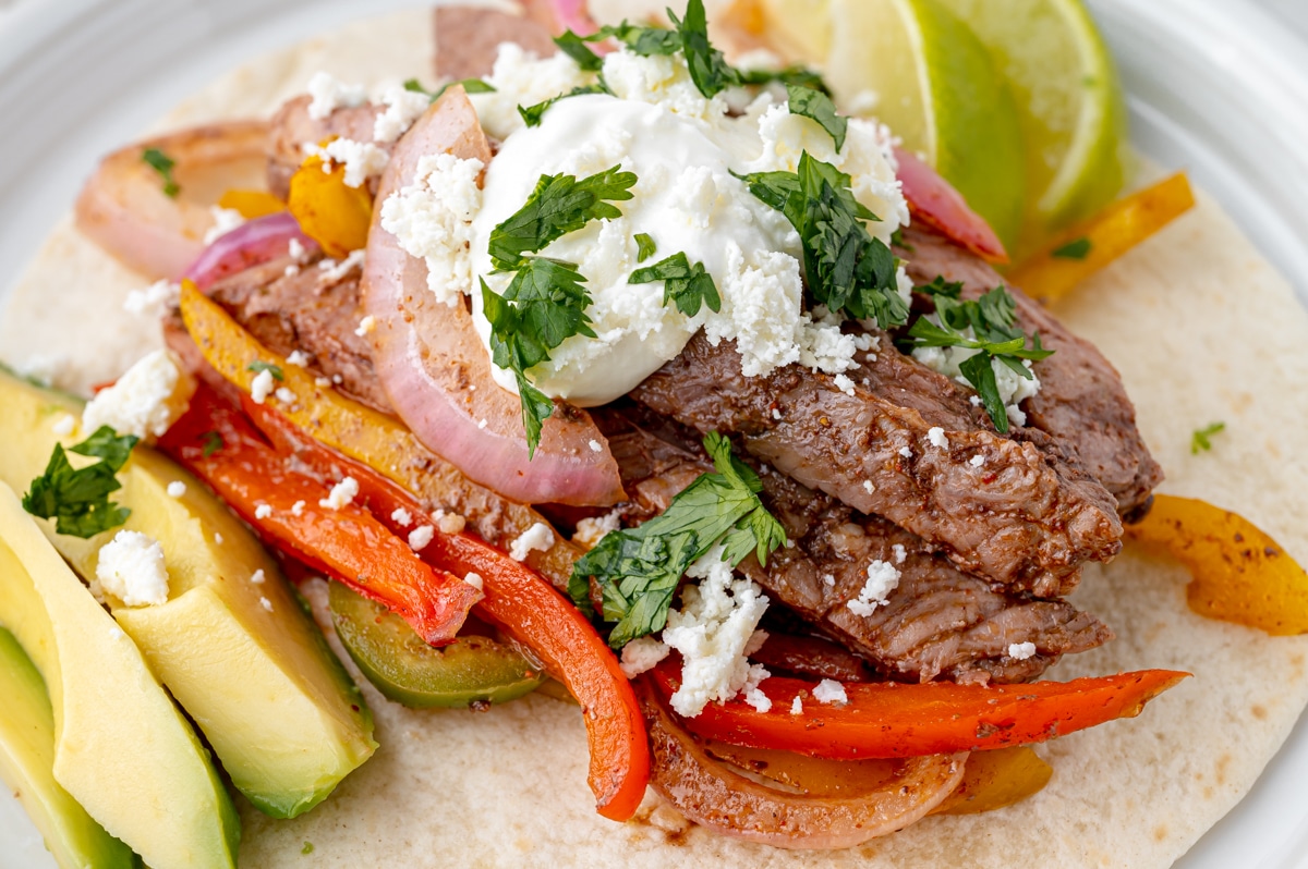 close up shot of sheet pan steak fajitas on a plate