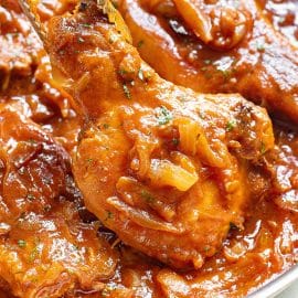 close up of smothered pork chops in a pan