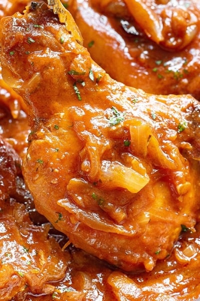 close up of smothered pork chops in a pan