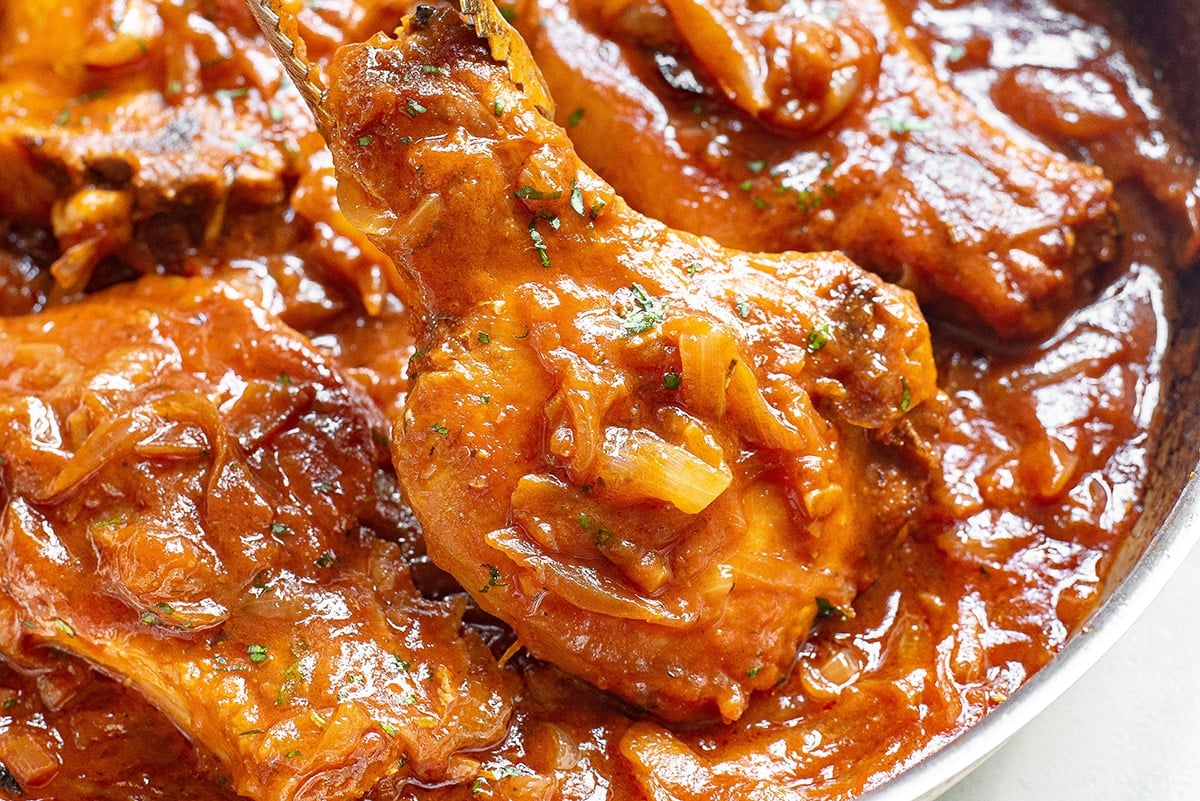 close up of smothered pork chops in a pan