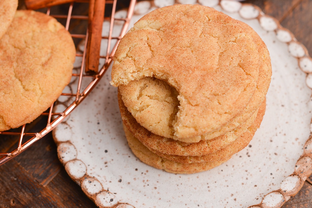 angled shot of bite taken out of stack of snickerdoodle cookies