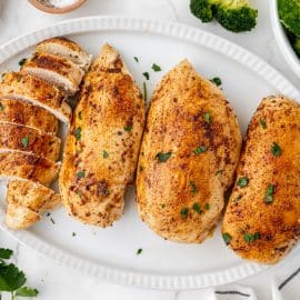 overhead shot of baked chicken breasts on a platter