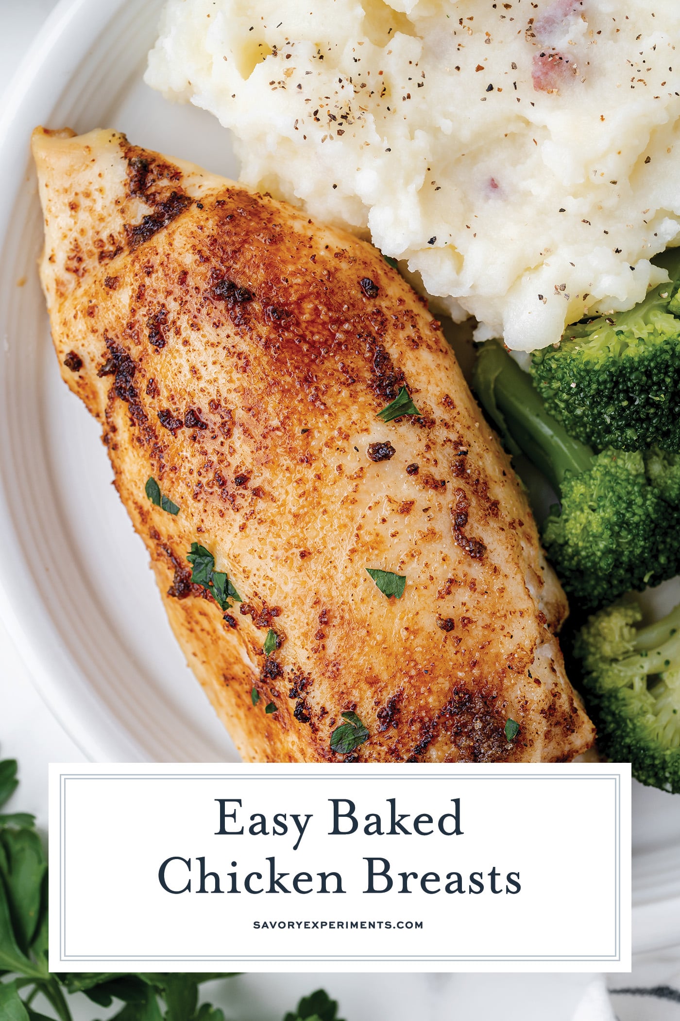 angled shot of baked chicken breast on a plate with text overlay for pinterest