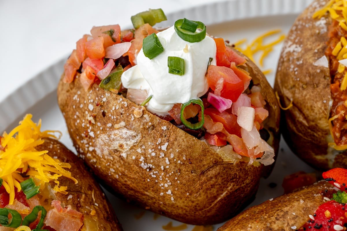 angled shot of baked potato topped with pico de gallo