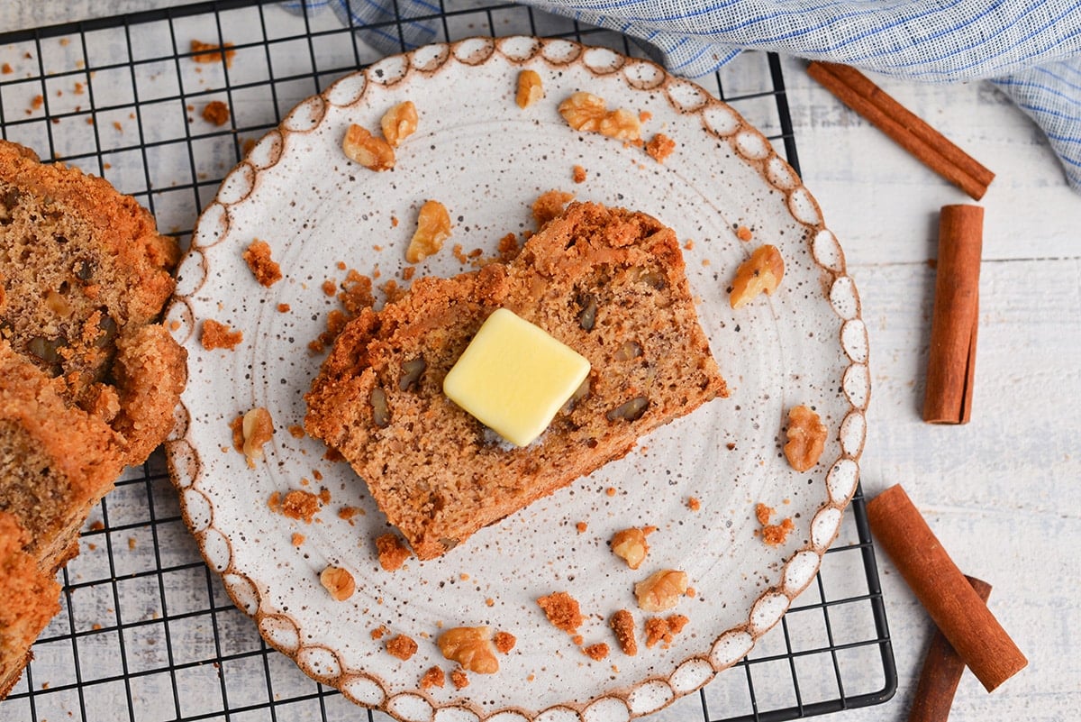 overhead of slice of banana bread with a pat of butter