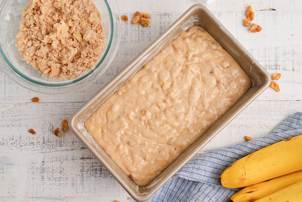 overhead of banana bread batter in a greased loaf pan