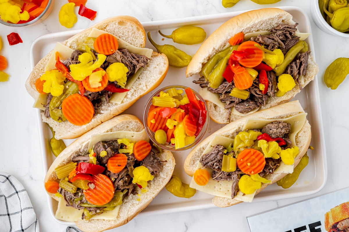 overhead shot of four italian beef sandwiches on tray
