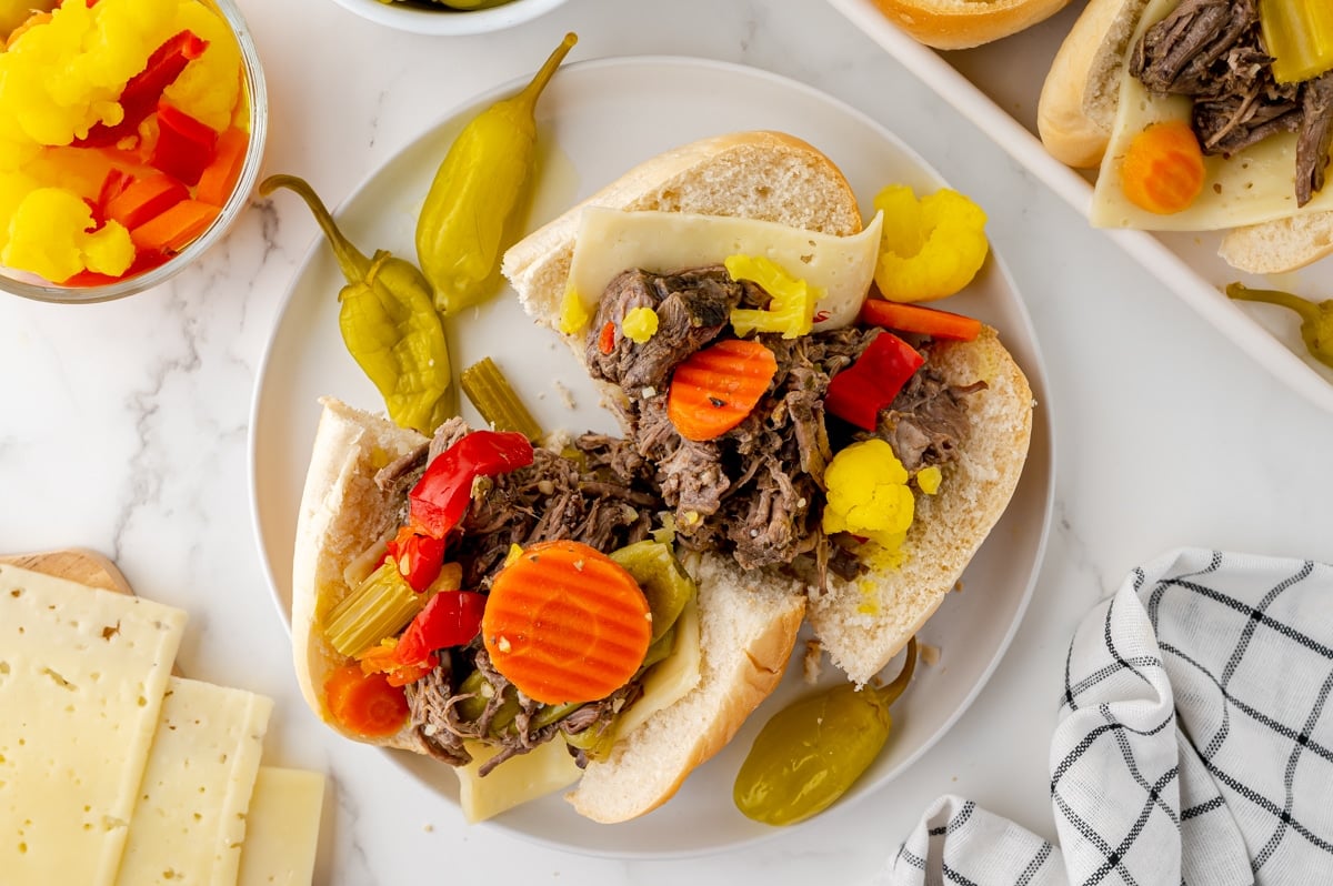 overhead shot of italian beef sandwich cut in half on a plate