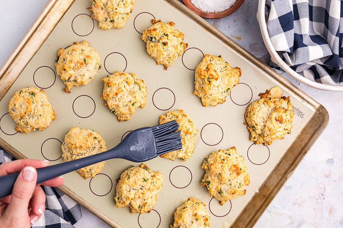 brushing butter onto baked biscuits