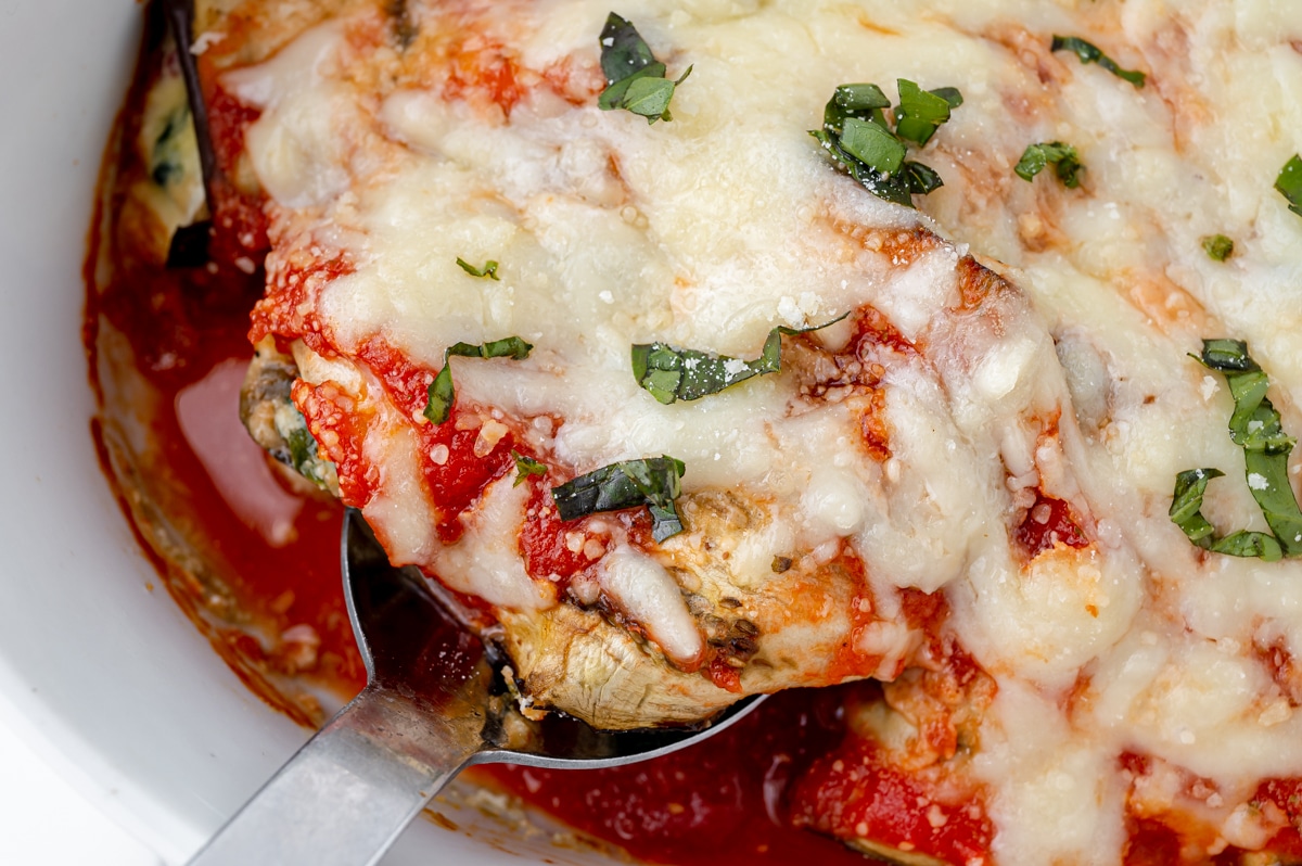 overhead shot of serving spoon in dish of eggplant rollatini