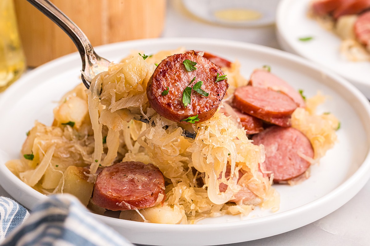 bite of kielbasa and sauerkraut on fork