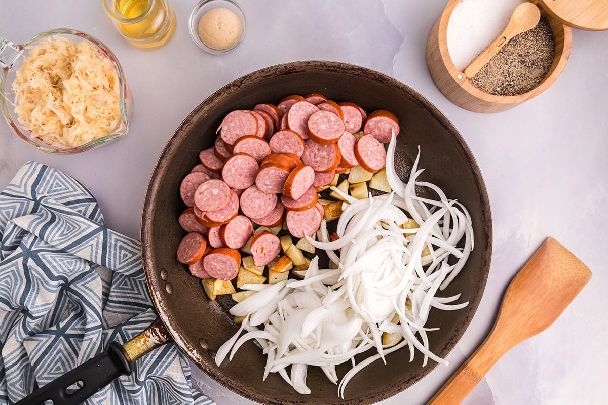 onions and kielbasa added to pan of potatoes