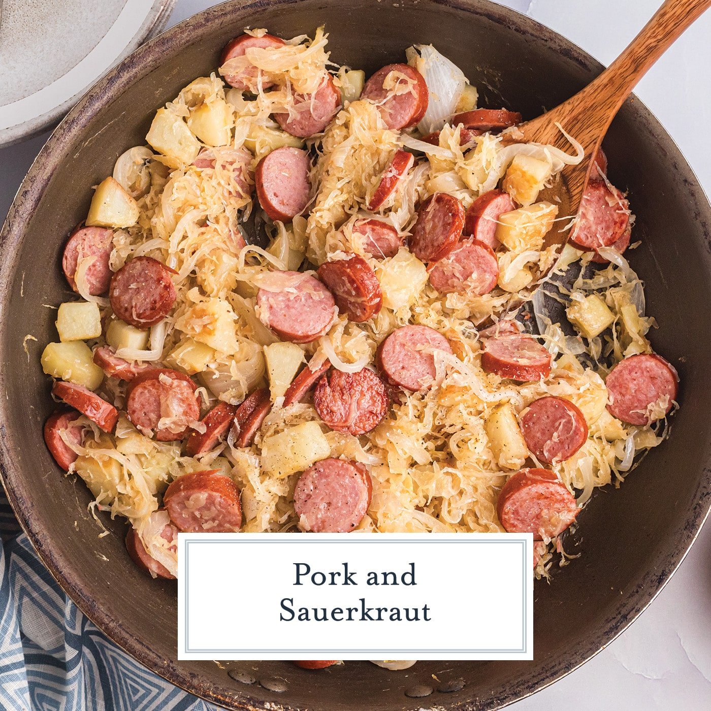 overhead shot of skillet of pork and sauerkraut with text overlay for facebook