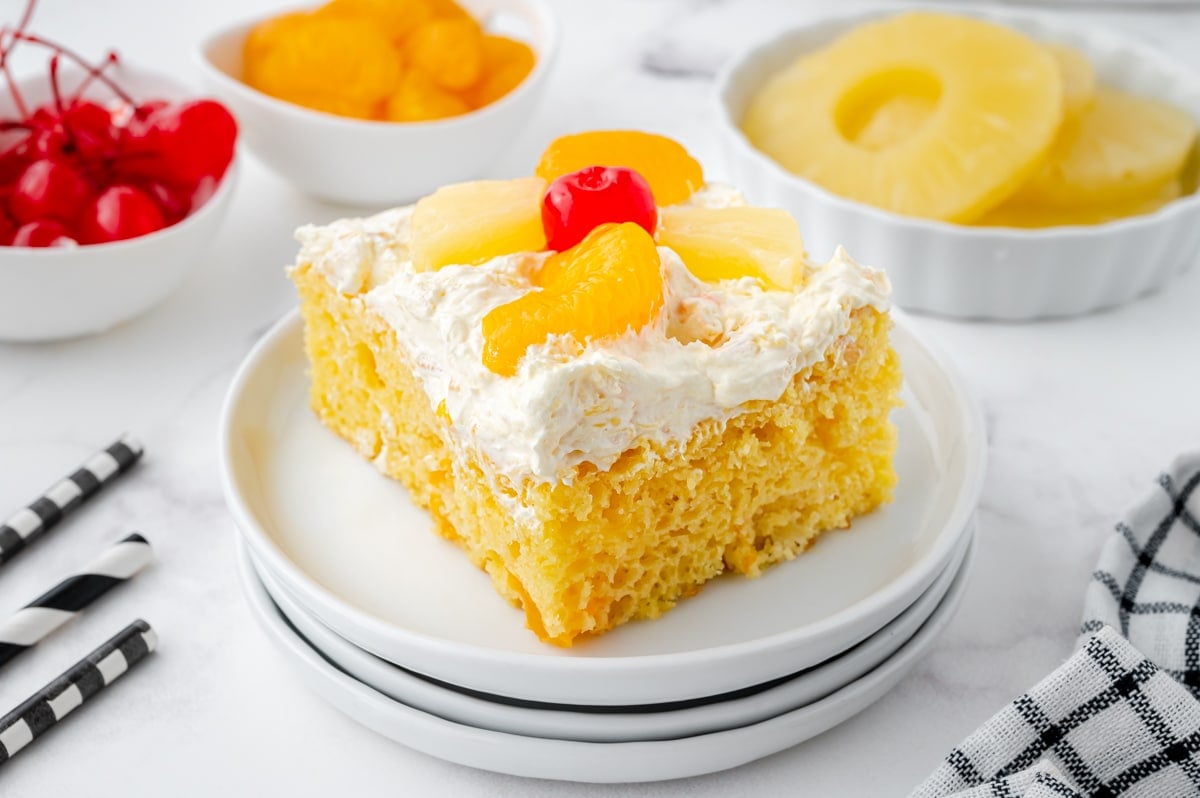 angled shot of slice of sunshine cake on stack of three plates