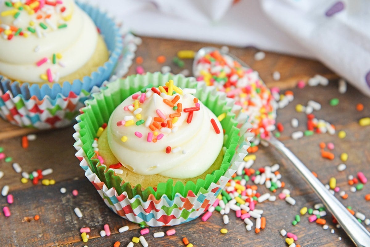 angle of cupcakes with vanilla frosting and sprinkles