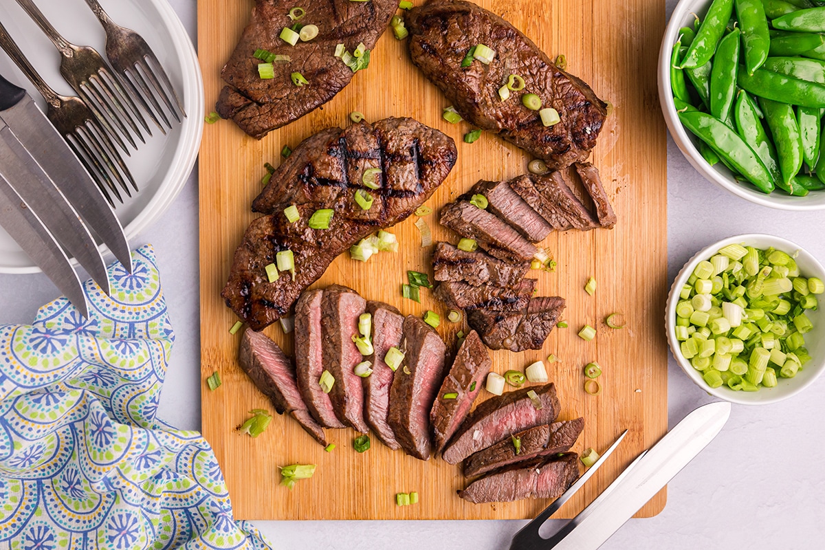 overhead shot of steak sliced on cutting board