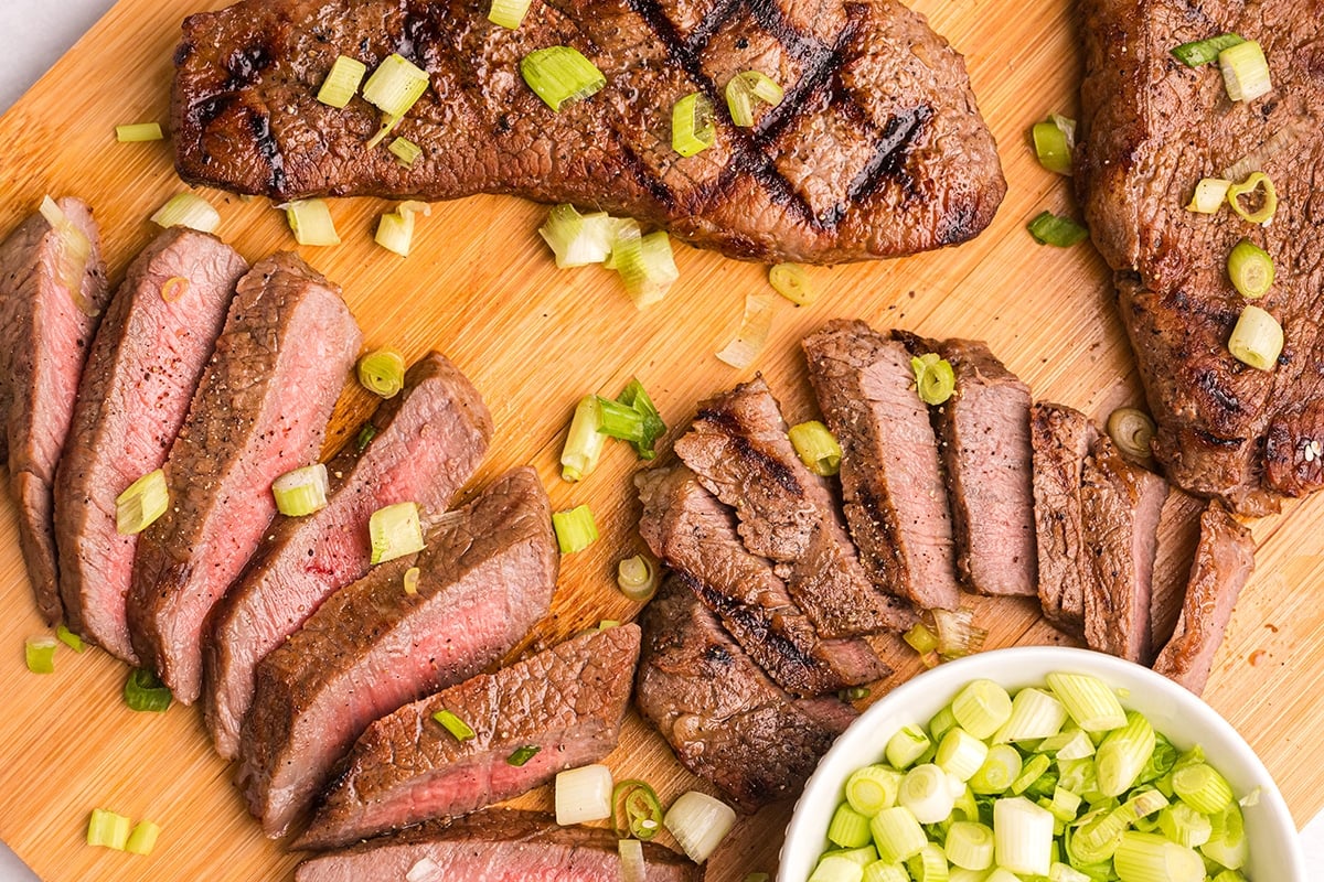 overhead shot of sliced asian steak on cutting board