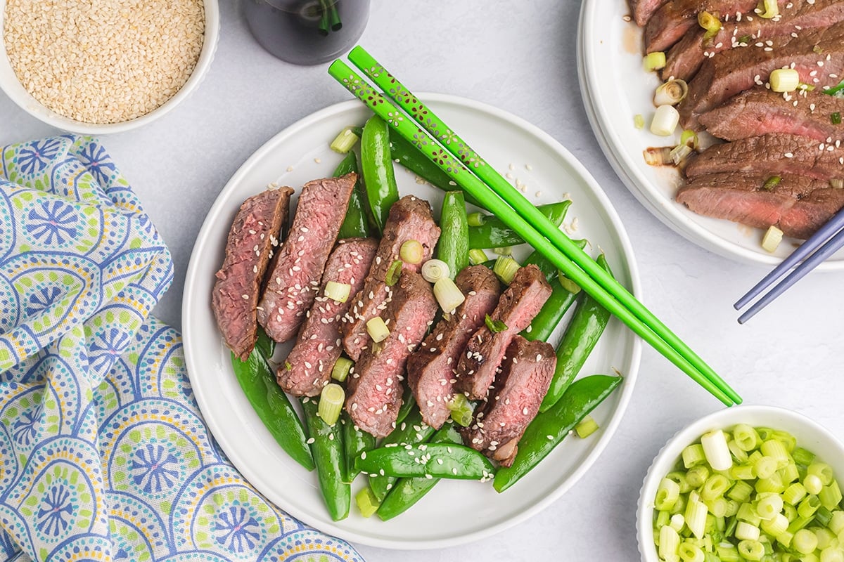 zoomed out overhead shot of sliced asian steak on a plate
