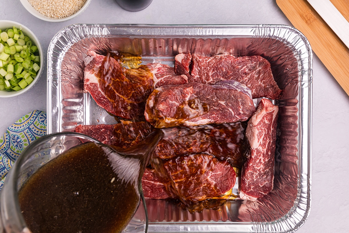 asian steak marinade poured over steak