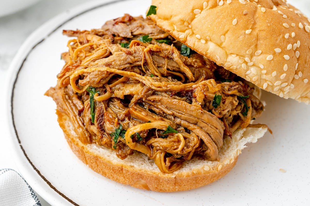 angled shot of instant pot pulled pork on a bun