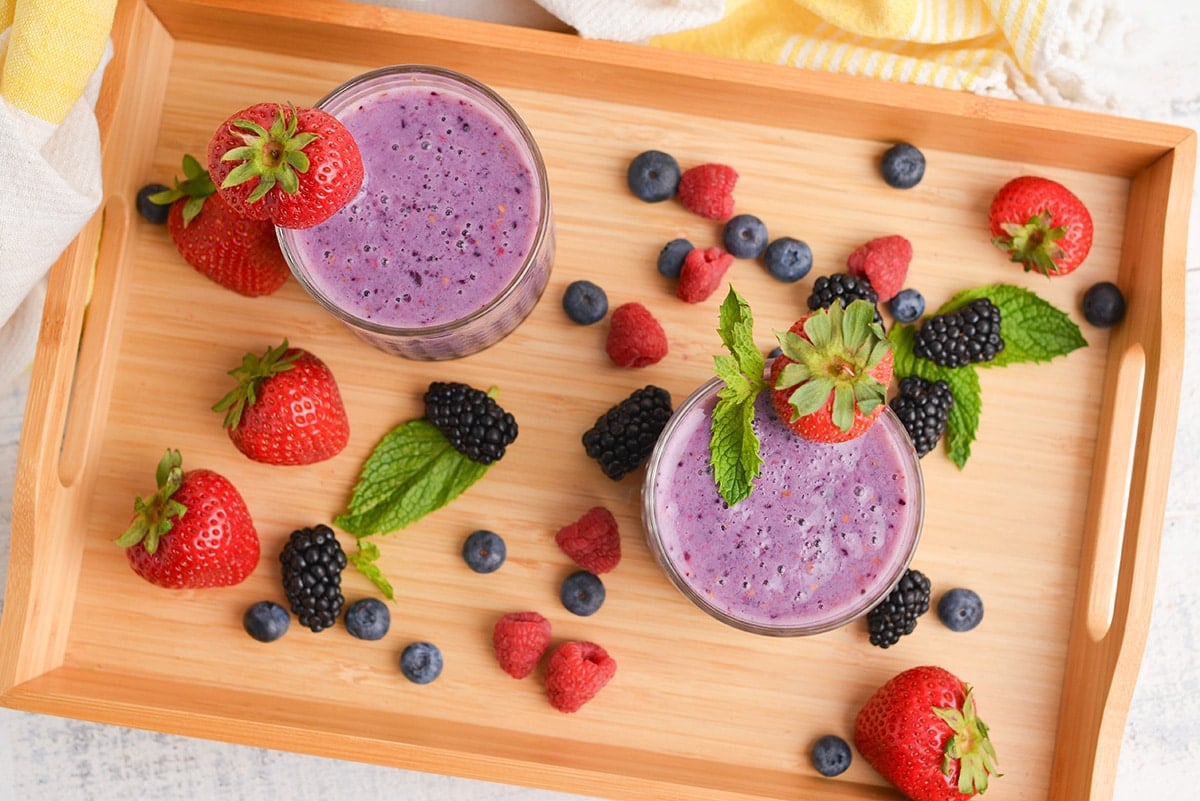 overhead shot of two berry smoothies on a tray