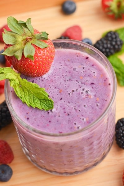 angled shot of glass of berry smoothie