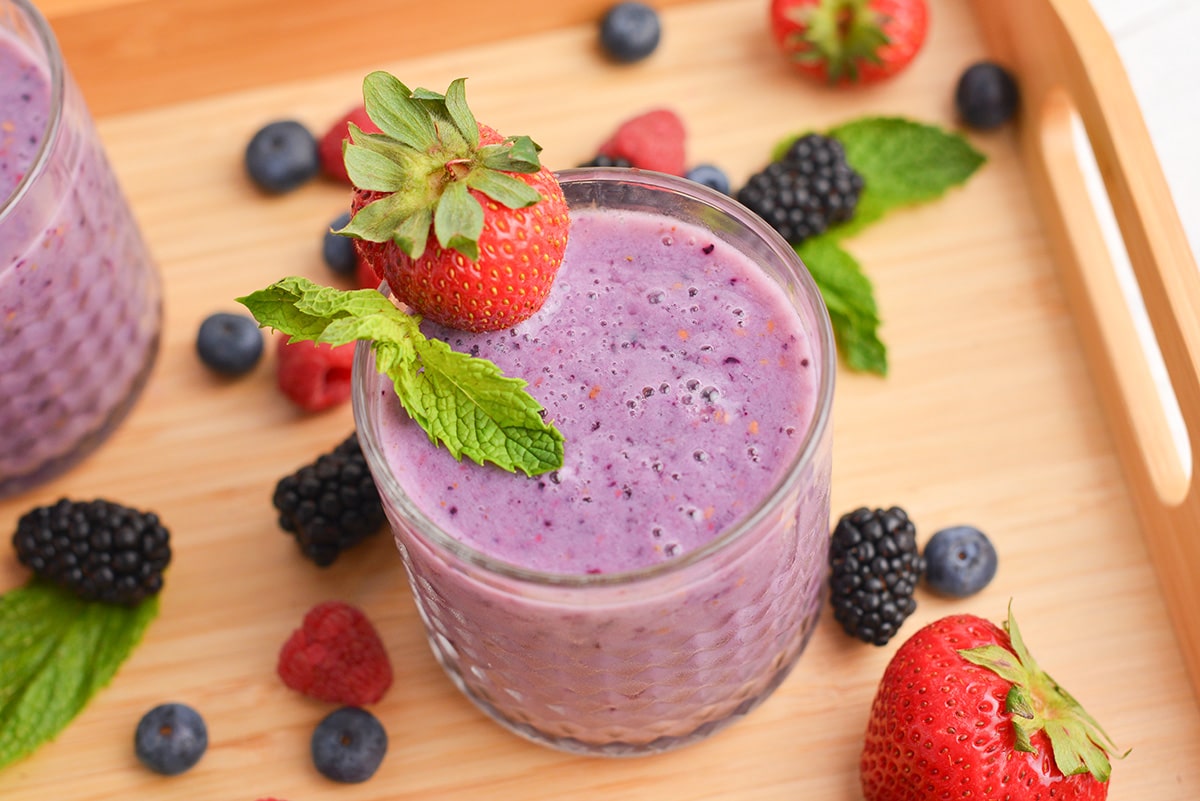 angled shot of glass of berry smoothie