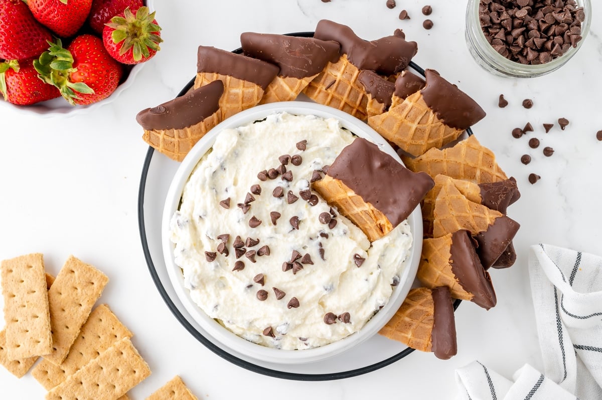 overhead shot of waffle cone piece in bowl of cannoli dip