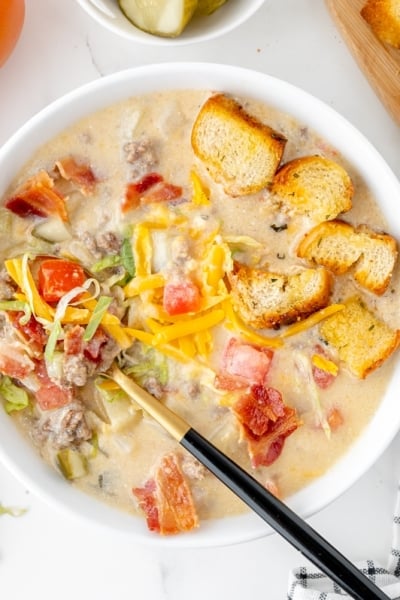 overhead shot of cheeseburger soup with spoon in bowl