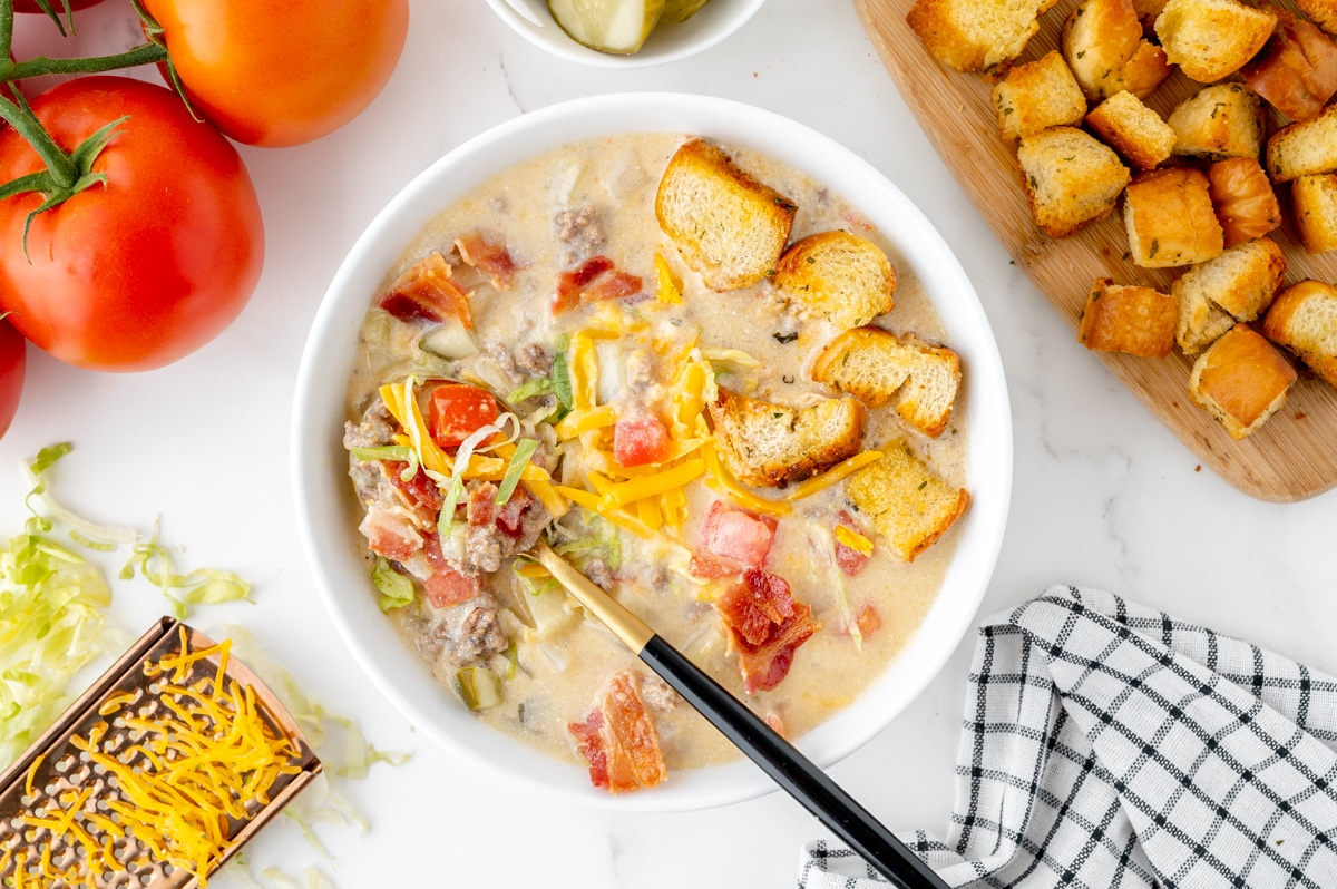 overhead shot of cheeseburger soup with spoon in bowl