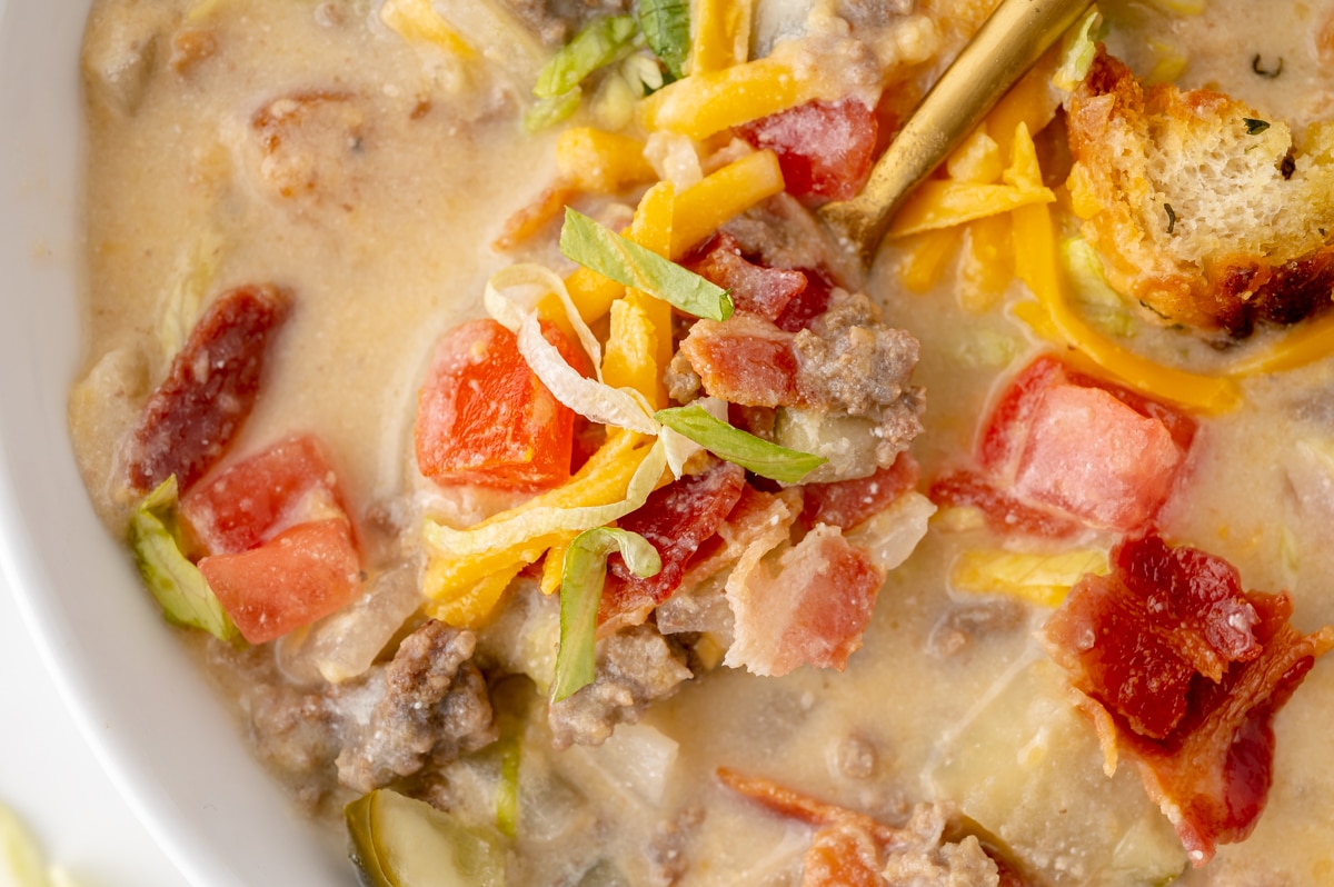 close up of bite of cheeseburger soup on spoon