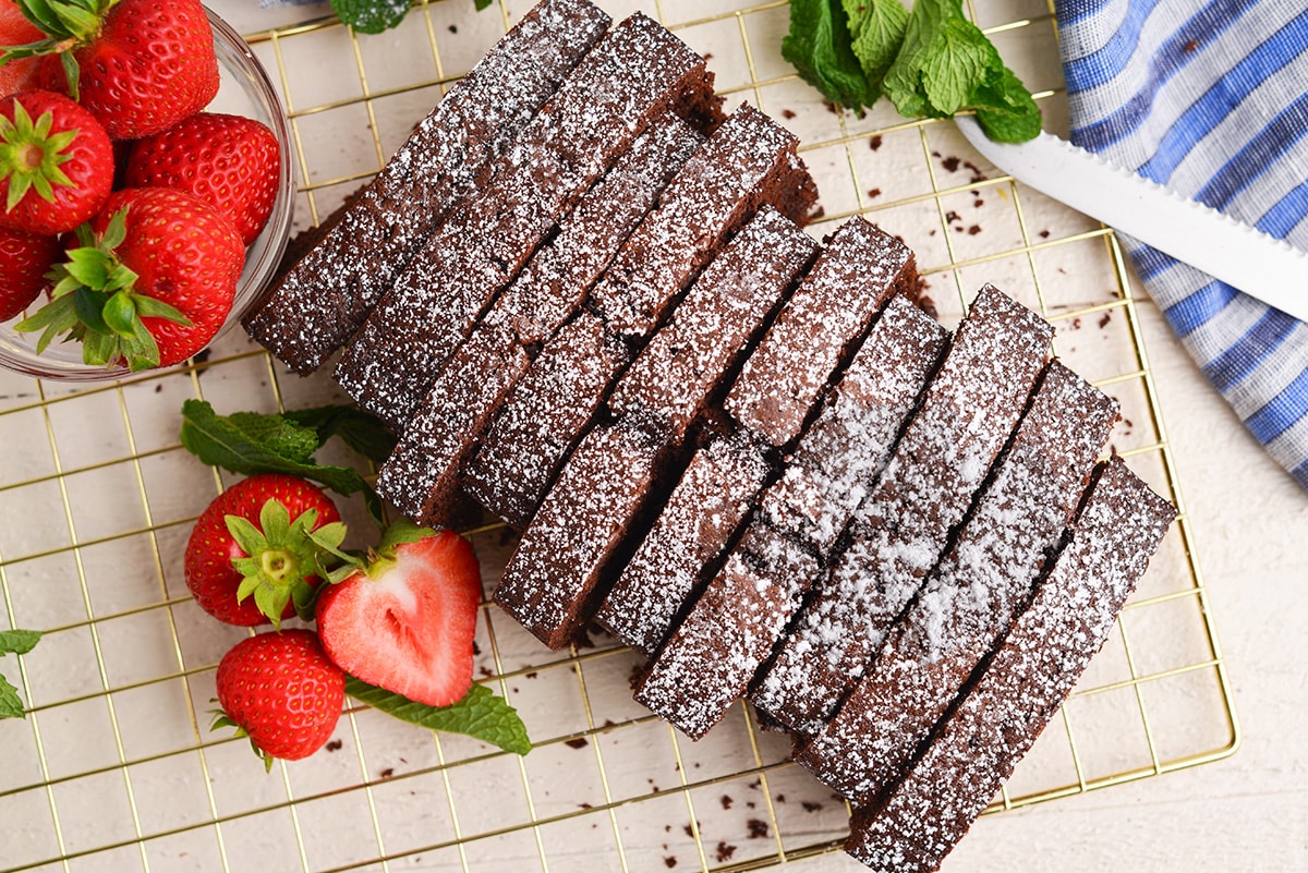 sliced chocolate pound cake on a gold wire cooling rack