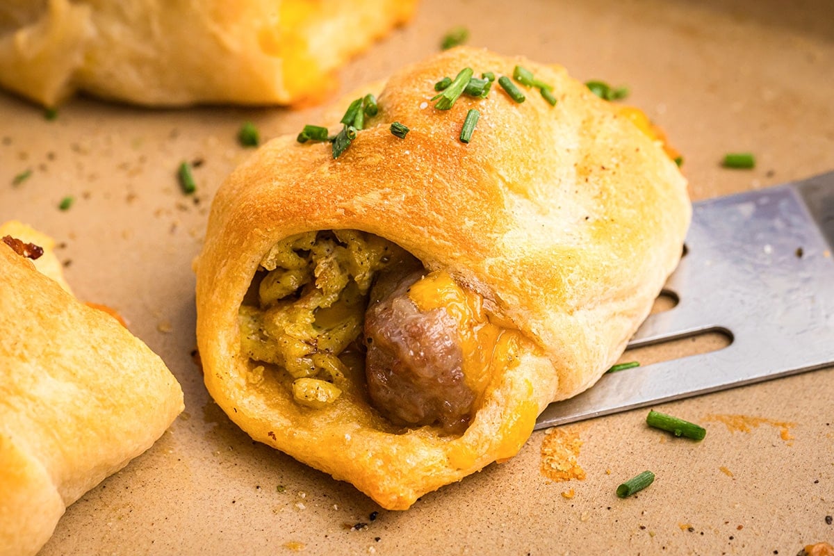 close up of scrambled eggs and sausage in a crescent roll