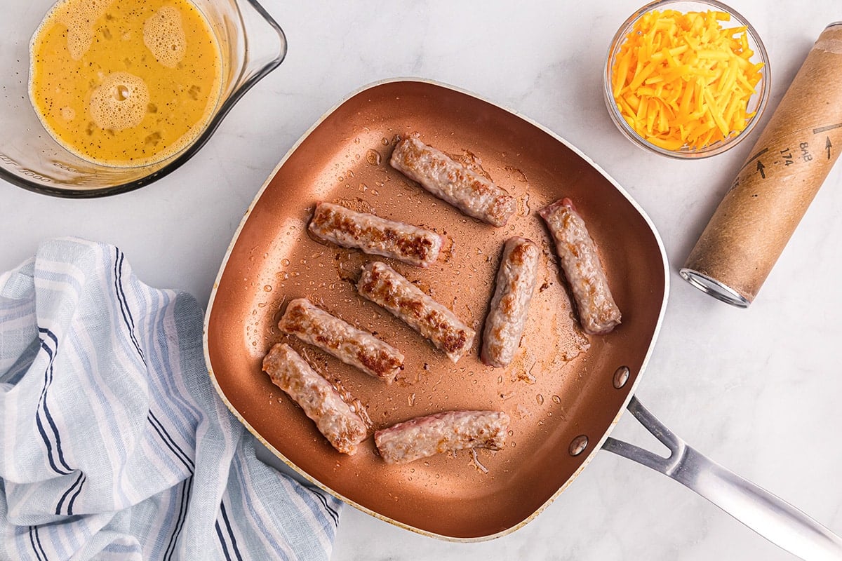 cooking sausage links in a skillet