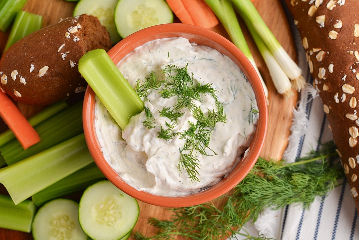 overhead shot of celery in bowl of dill dip