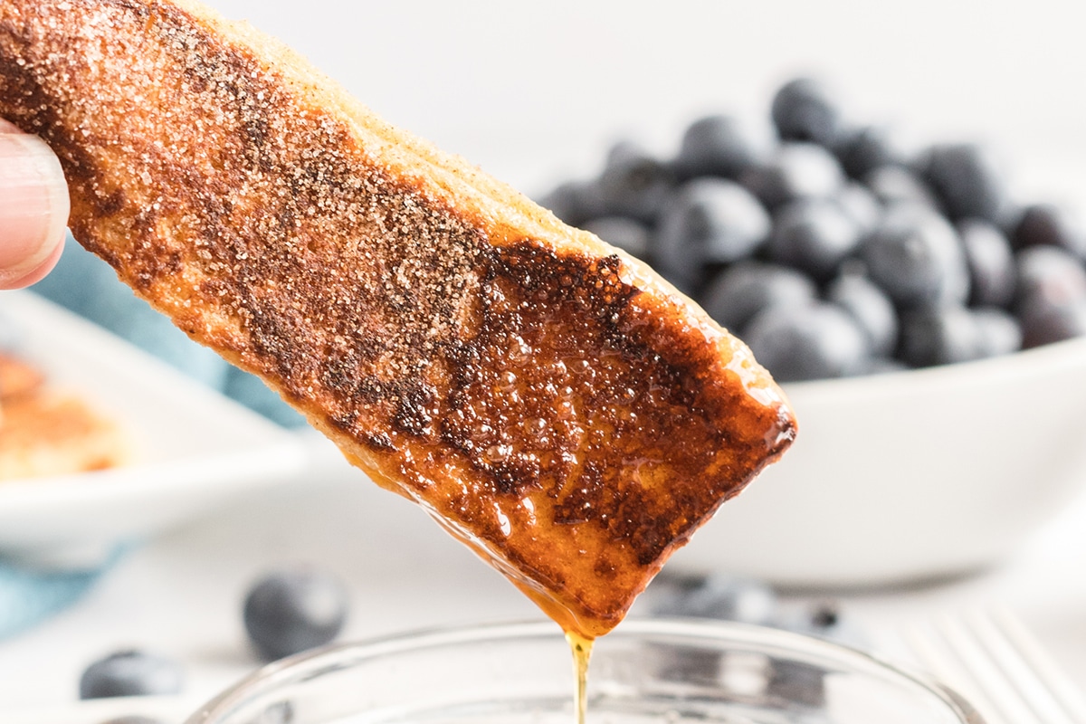 french toast stick dipped into syrup