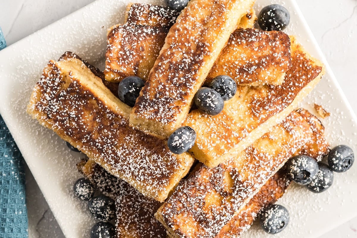 close up overhead shot of french toast sticks on plate with blueberries